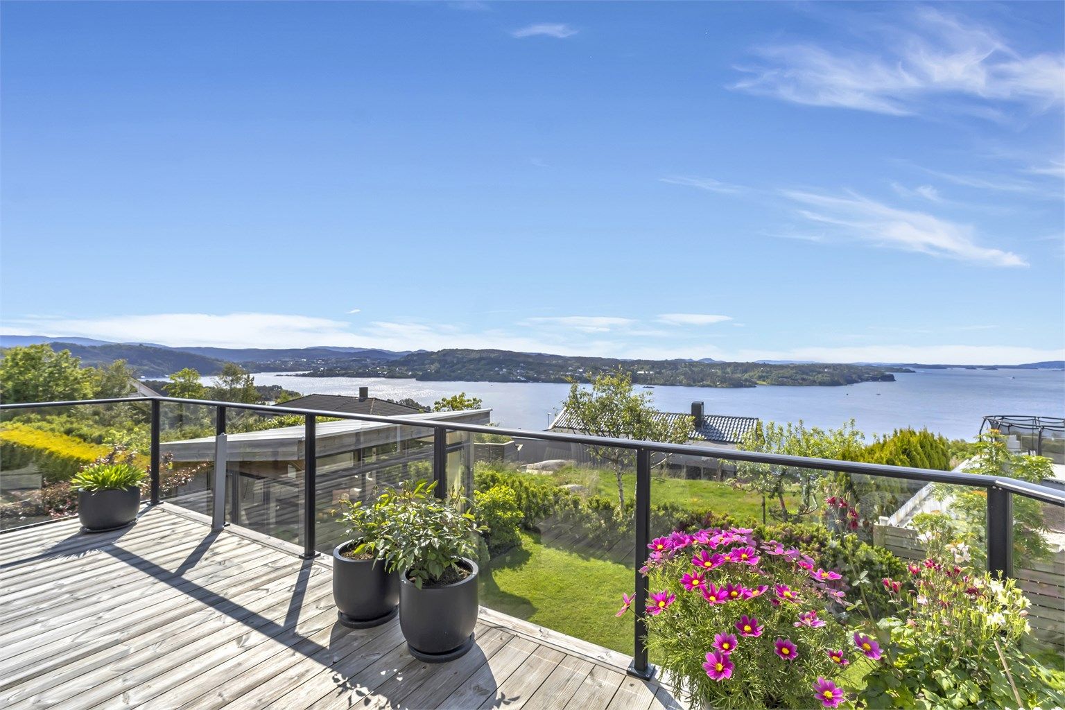 Utgang fra stue til stor veranda med nydelige lys- og utsiktsforhold