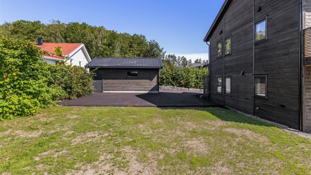 Lettholdt, asfaltert gårdsplass samt plensatt hage