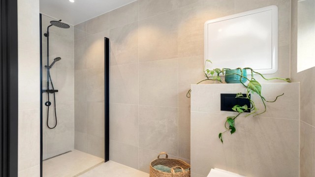 Romslig dusjnisje med dusjvegg i glass. Armatur med regnfallsdusj og hånddusj