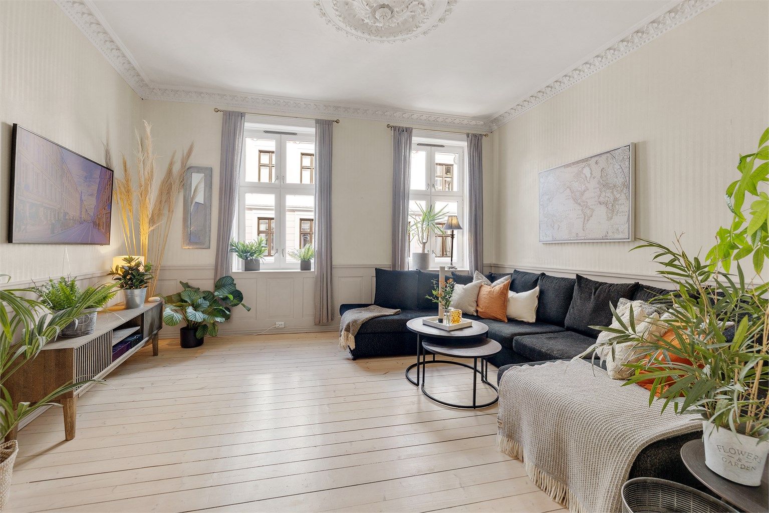 Lys og romslig stue med originale tregulv, god takhøyde og store vinduer som bidrar med masse naturlig lys.