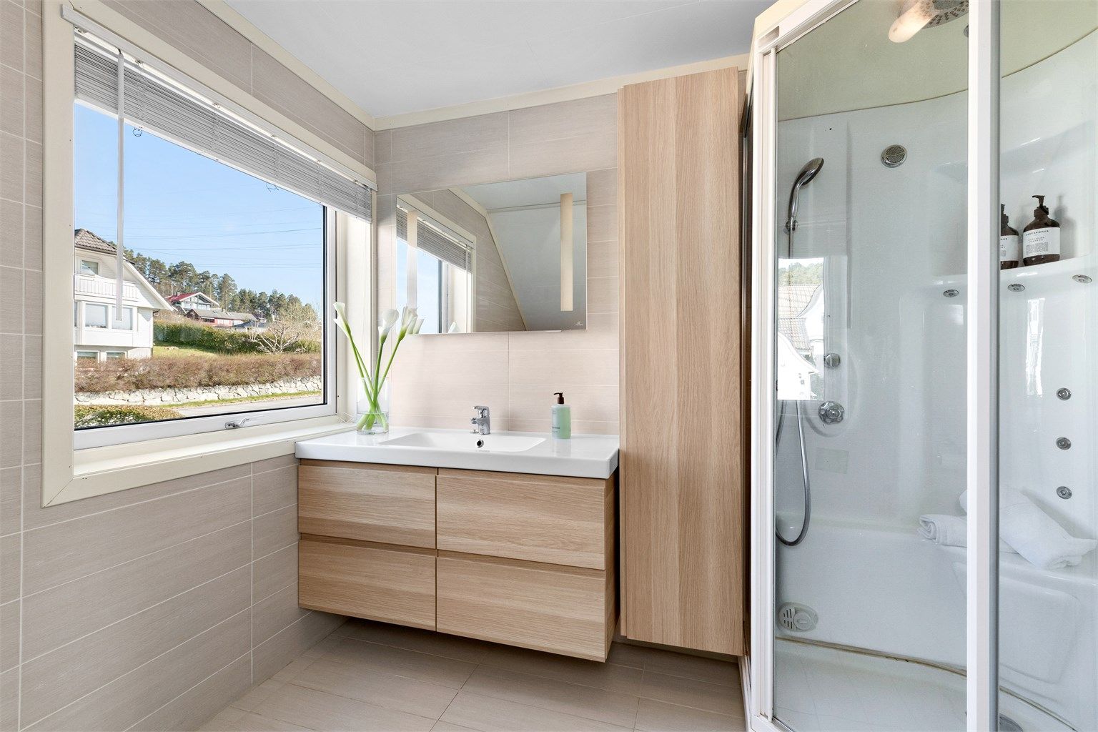 Store fliser på gulv og vegger, og et stort vindu som slipper inn rikelig med dagslys