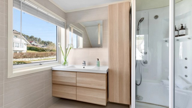 Store fliser på gulv og vegger, og et stort vindu som slipper inn rikelig med dagslys