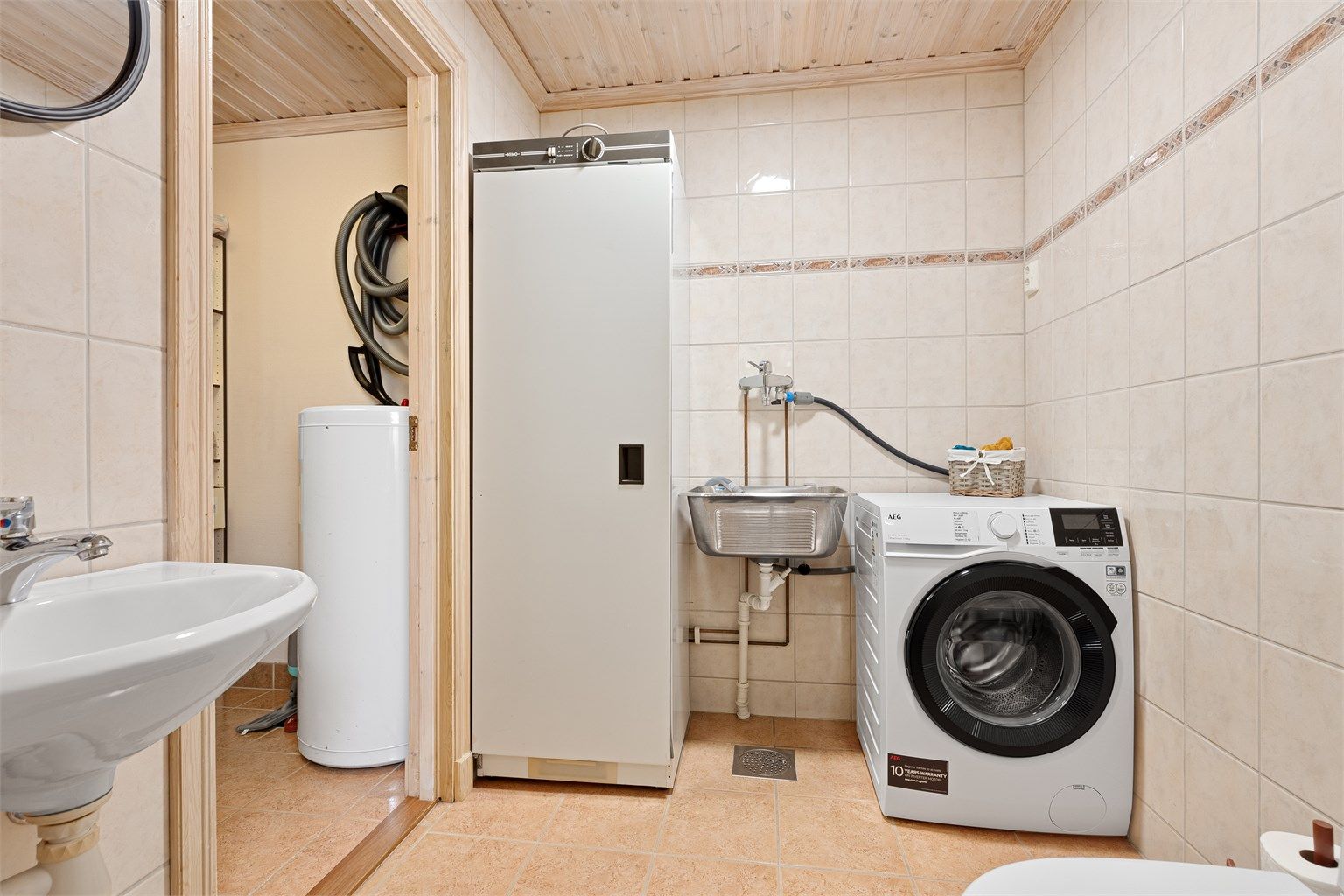 Rommet har opplegg for vaskemaskin, utslagsvask og tørkeskap.