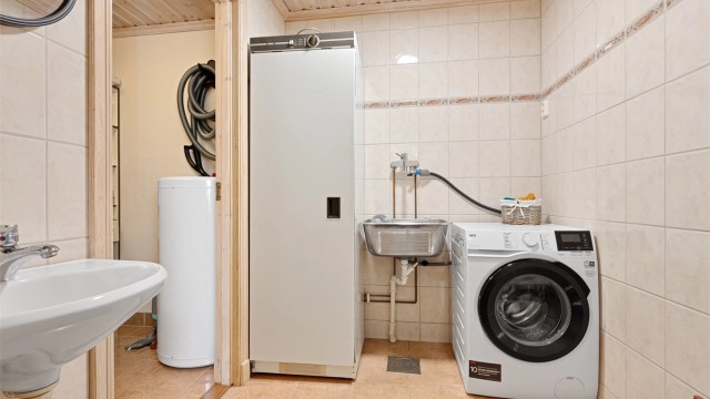 Rommet har opplegg for vaskemaskin, utslagsvask og tørkeskap.