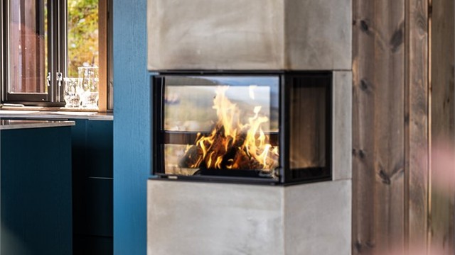 Peisovnen med glass på to sider gir innsyn til flammene fra både stue og kjøkken.