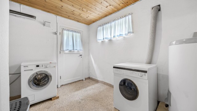 Praktisk vaskerom i kjelleren med opplegg for vaskemaskin og plass til varmtvannsbereder.