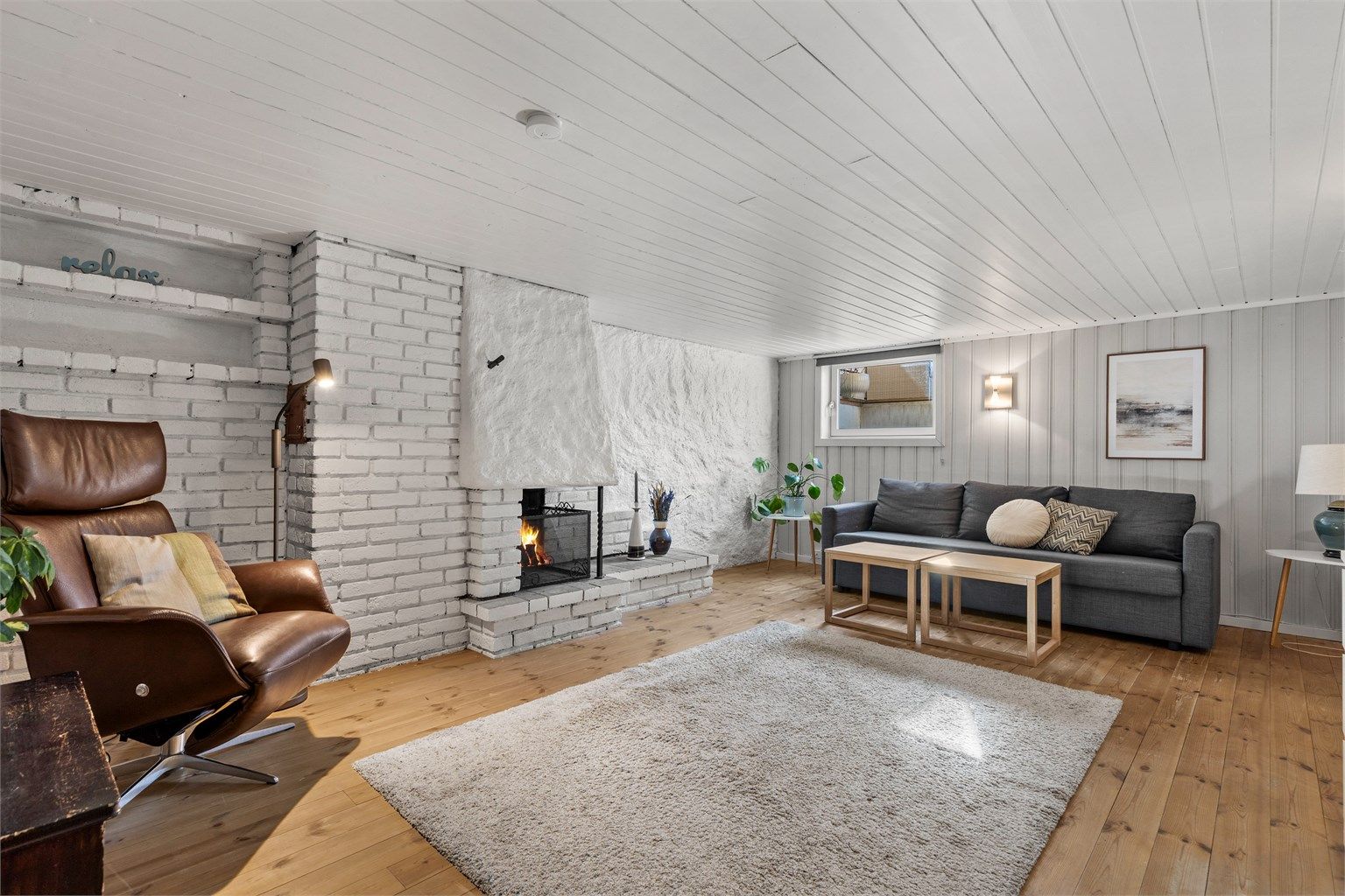 Kjellerstuen med åpen peis. Rommet er ikke godkjent for varig opphold.