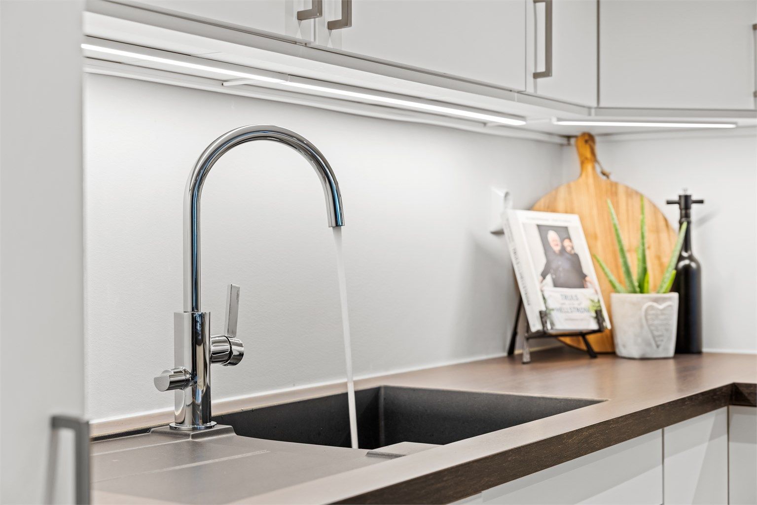 Stilrent armatur og god belysning over arbeidsflatene.