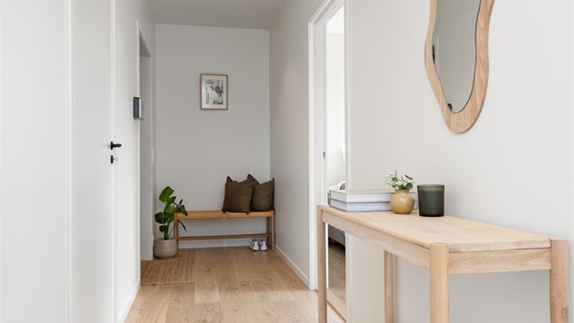 Entréen er lys og innbydende med listfrie overganger mellom vegg og tak.