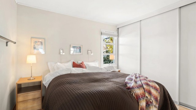 Romslig hovedsoverom med stor skyvedørsgarderobe