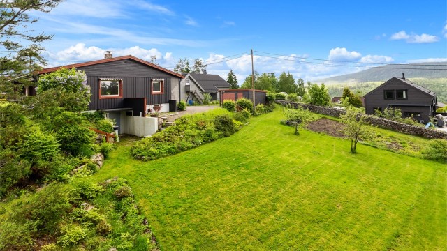 Eiendommen har en stor tomt som er pent opparbeidet med plen og beplantning. I store deler av grensen er det etablert en håndstablet steingjerde som markeder skillet for tomten