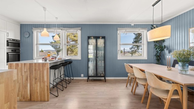 Spisestuen har plass til et stort langbord og har utsikt som strekker seg mot Østensjøvannet.