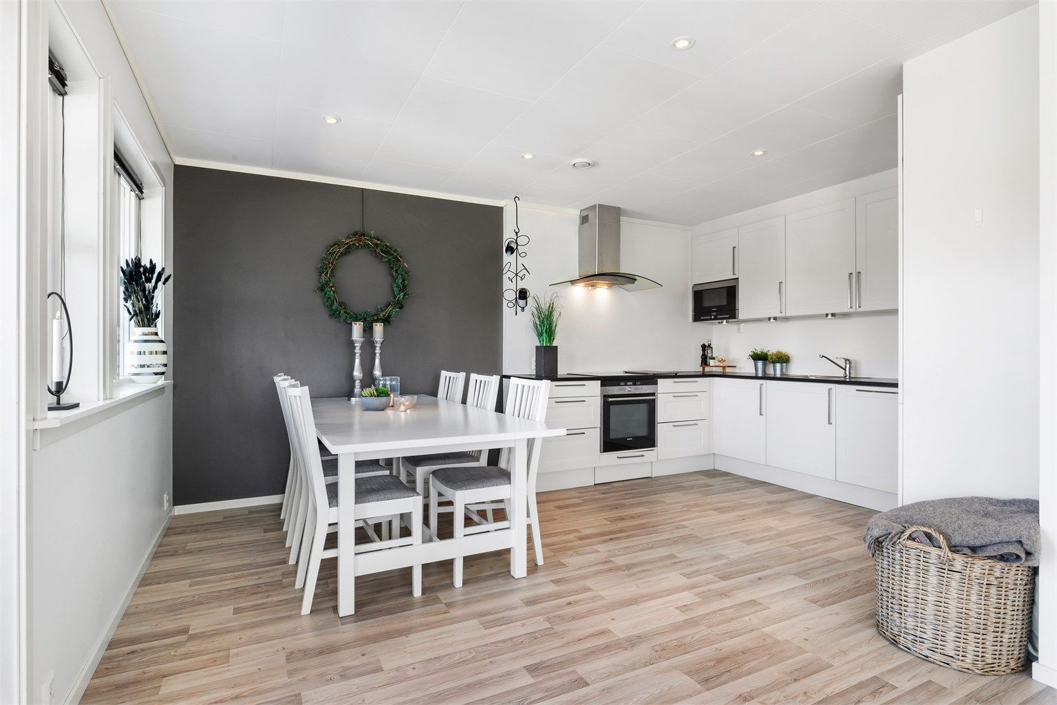 Over mot kjøkkendelen, er det i overgangen mellom sonene innredet med spisegruppe. Kontrastveggen gir en fin brytning mot de ellers lyse overflatene