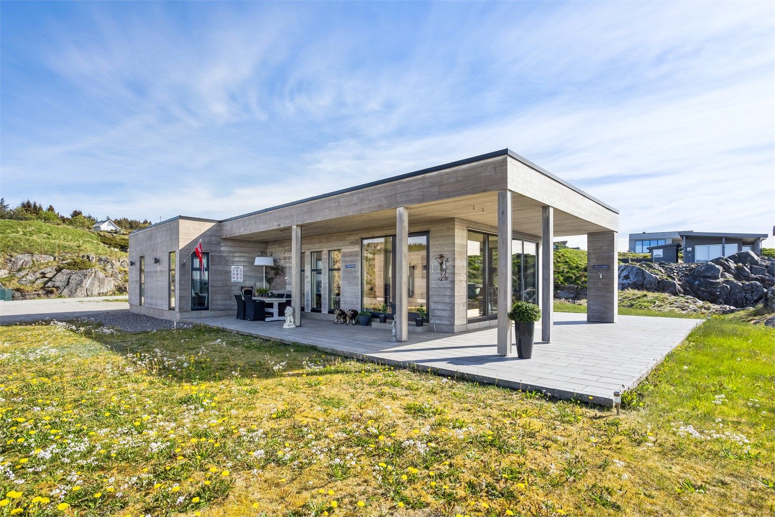 Et fantastisk flott arkitektonisk bygg som er omkranset av flere flotte uteplasser på en 117 kvm markterrasse belagt med betongheller. 