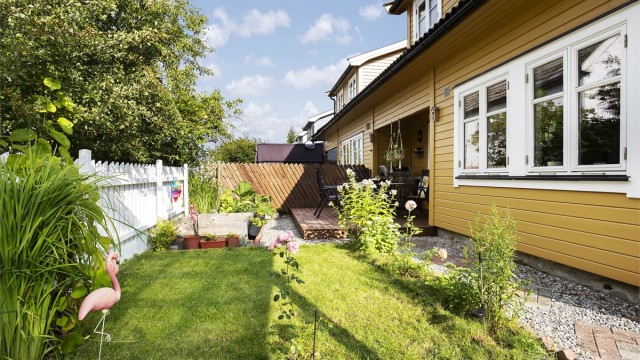 Hagen er pent opparbeidet med plen og beplantning.