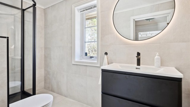 Lekkert oppusset bad med dusjkabinett, servantskap og vegghengt wc.