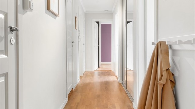Lys gang/entre med hvite profilerte innerdører. Skyvedørsgarderobe med god plass til oppbevaring av yttertøy og sko.