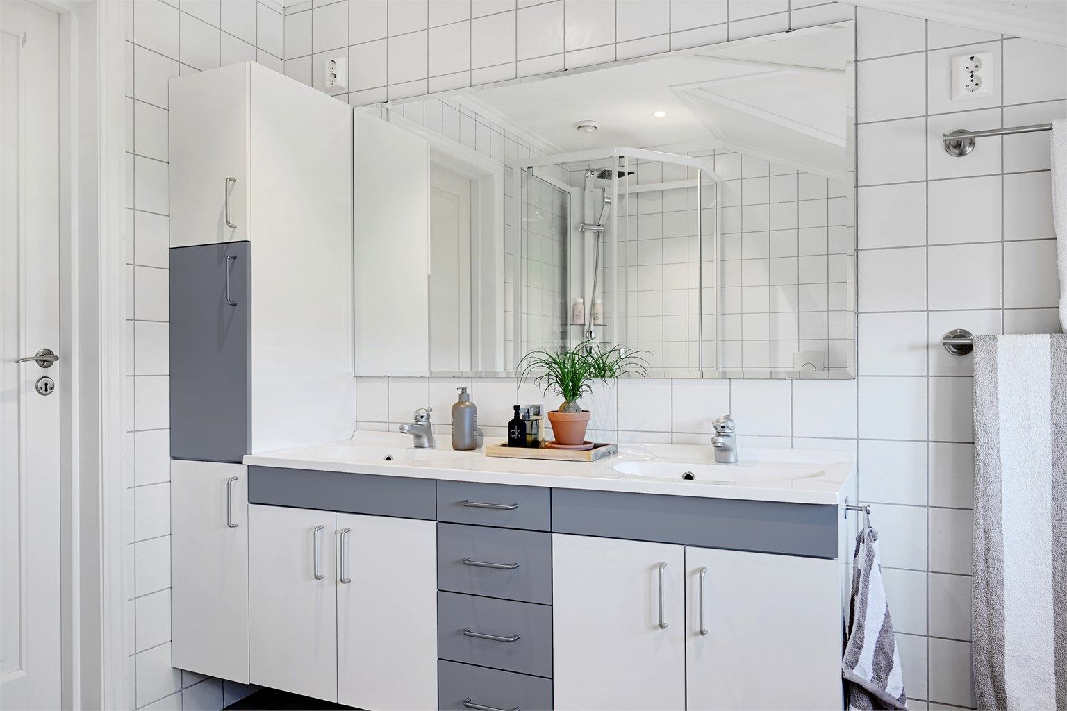 Baderomsinnredningen har doble servanter og god skapplass.