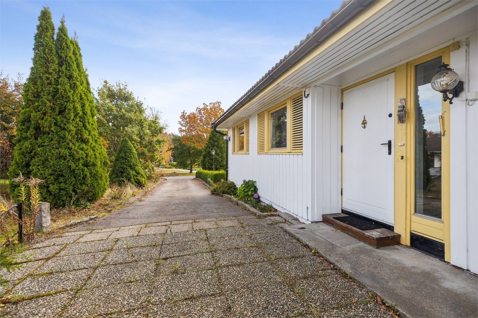 Hyggelig inngangsparti med steinlagt adkomst, via en asfaltert gårdsplass med parkeringsplasser. Boligen har i tillegg en garasjeplass i rekke.