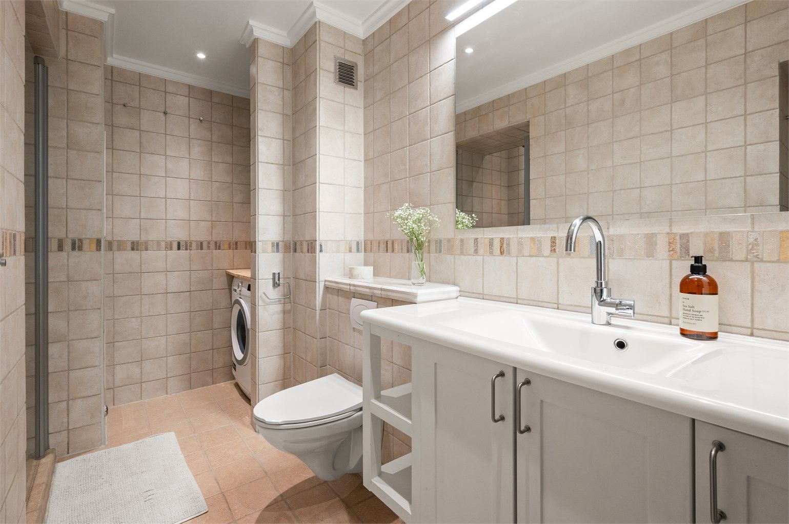 Flislagt bad med elektrisk gulvvarme for en behagelig start på dagen.