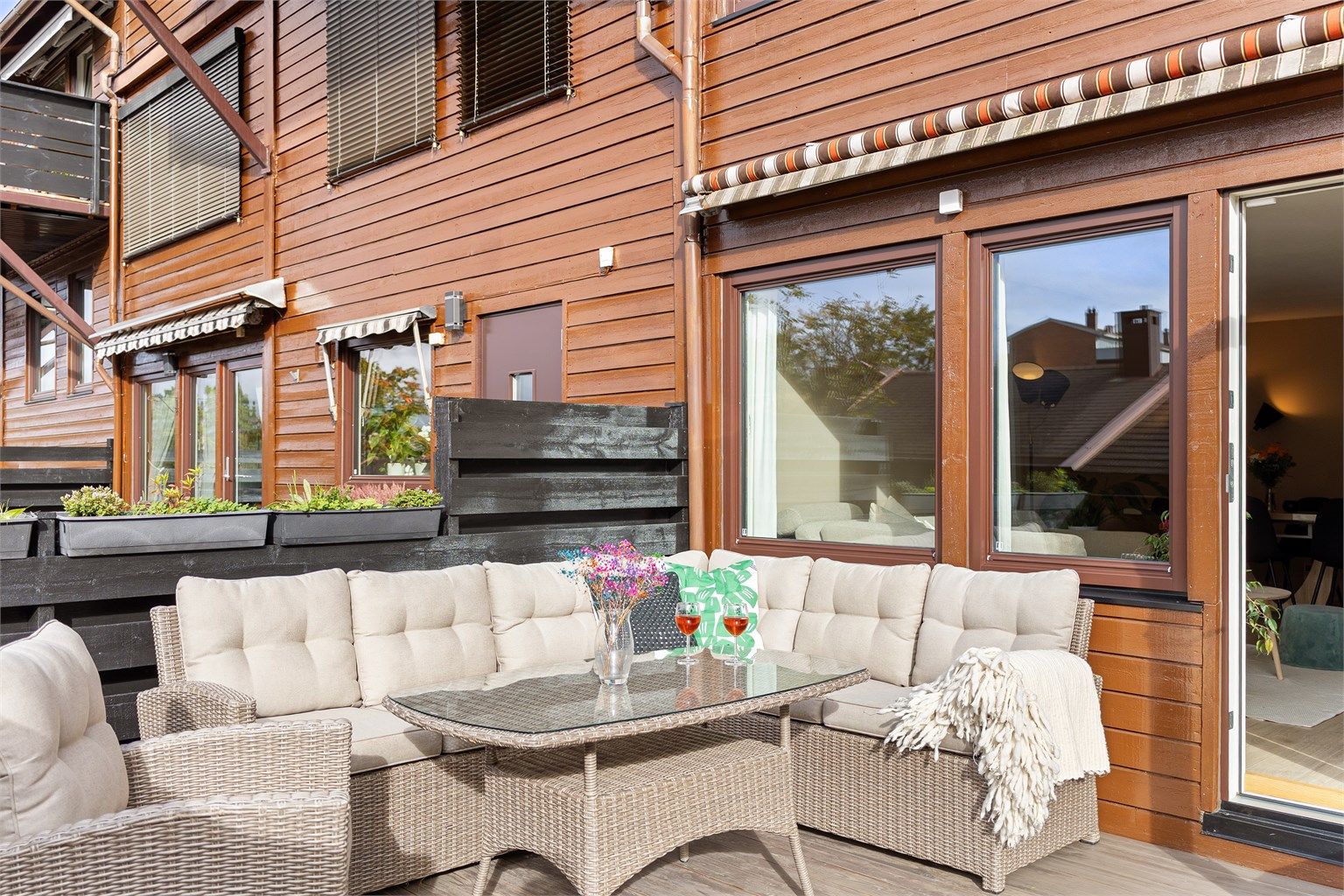 Terrassen har god plass til en stor sittegruppe og er utstyrt med veggmontert markise for behagelig solskjerming. Her kan man nemlig nyte sol fra våren og langt utover høsten, i en lun krok med gode solforhold. 