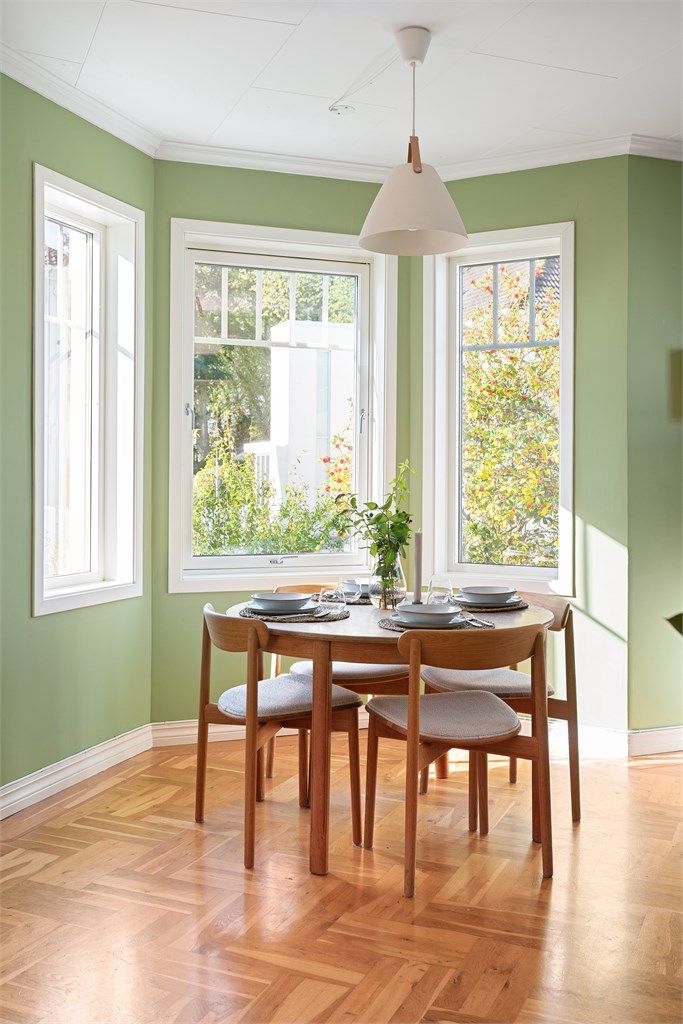 Spiseplass på kjøkken med gode lysforhold og utsyn til pent beplantet hage. 