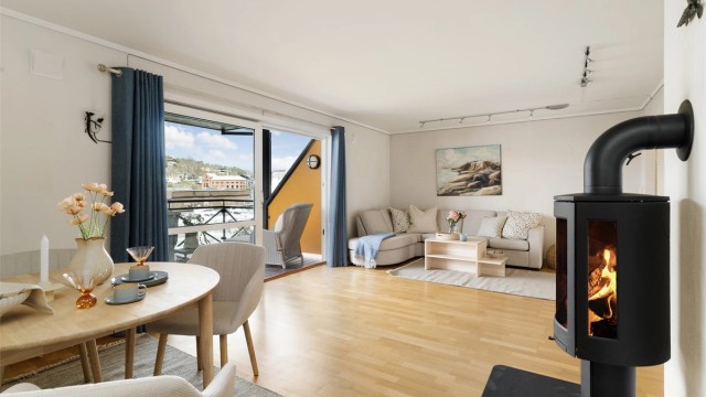 Peisovnen er sentralt plassert mellom stue og kjøkken, og skaper en naturlig soneinndeling.