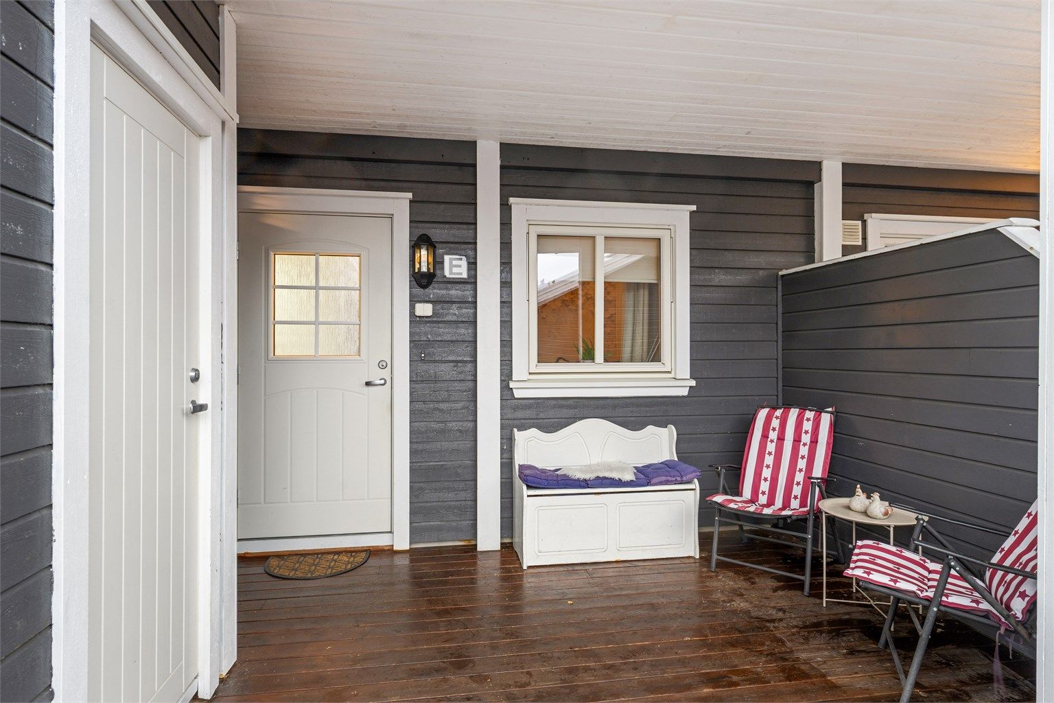 Overbygget inngangsparti med en terrasse på ca. 10 kvm og to utvendige boder