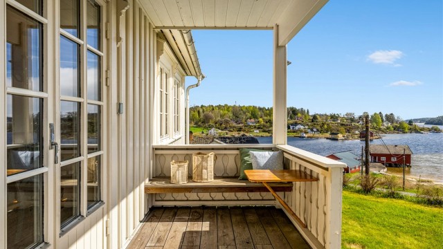 Fra stua er det direkte utgang til veranda med utsikt utover sjøen og stranda.
