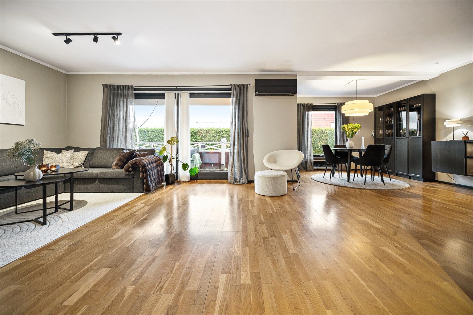 Romslig og åpen stue med parkett på gulv, malte flater på vegger og malte flater i himling