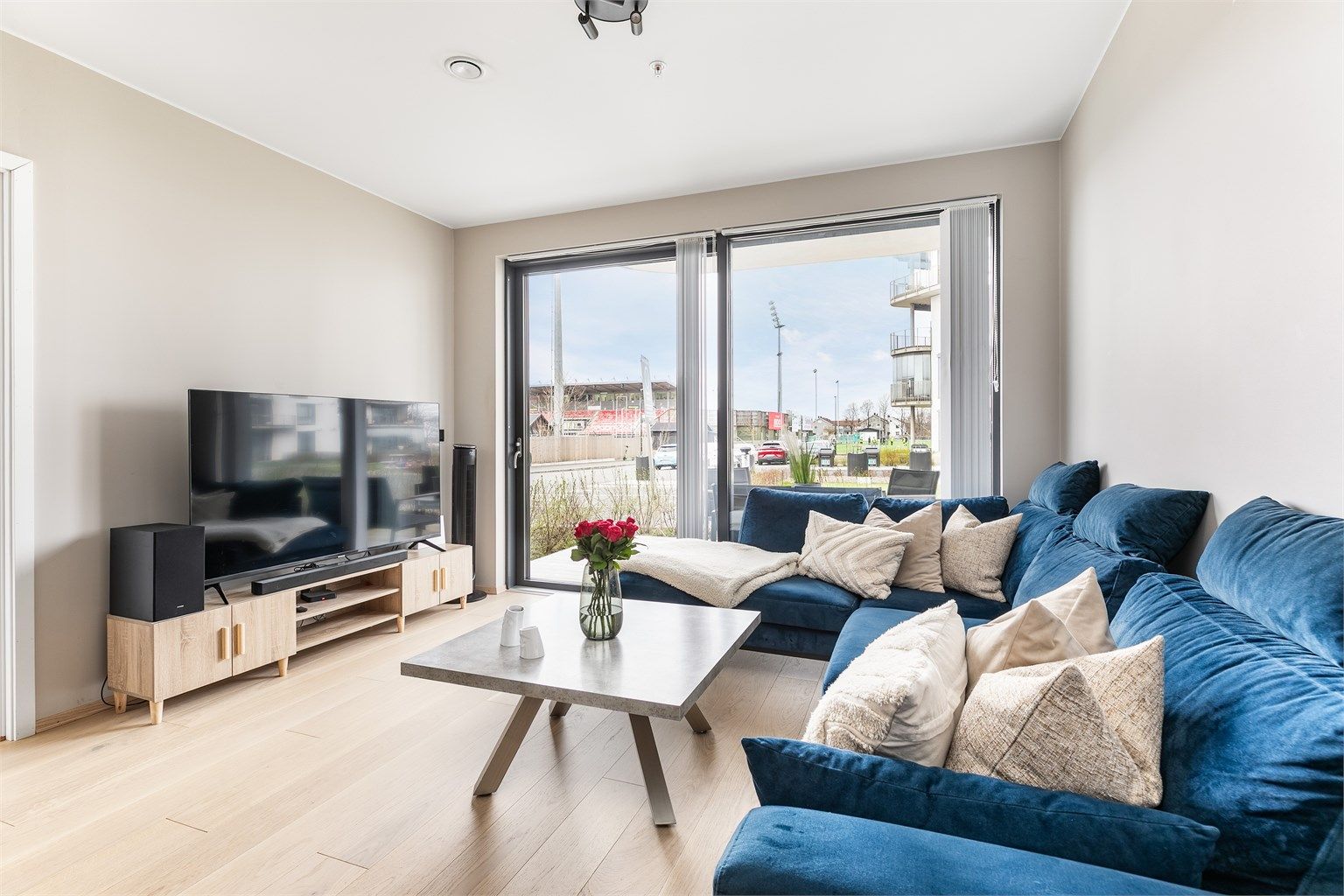 Store vinduer gir gode lysforhold og setter et luftig preg på stuen. Skyve-/hevedøren sikrer enkel tilgang til utearealet.