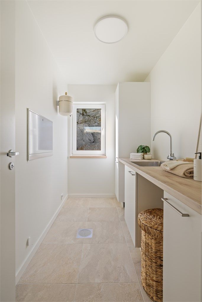 Praktisk, separat vaskerom med flislagt gulv og egen innredning med vask.