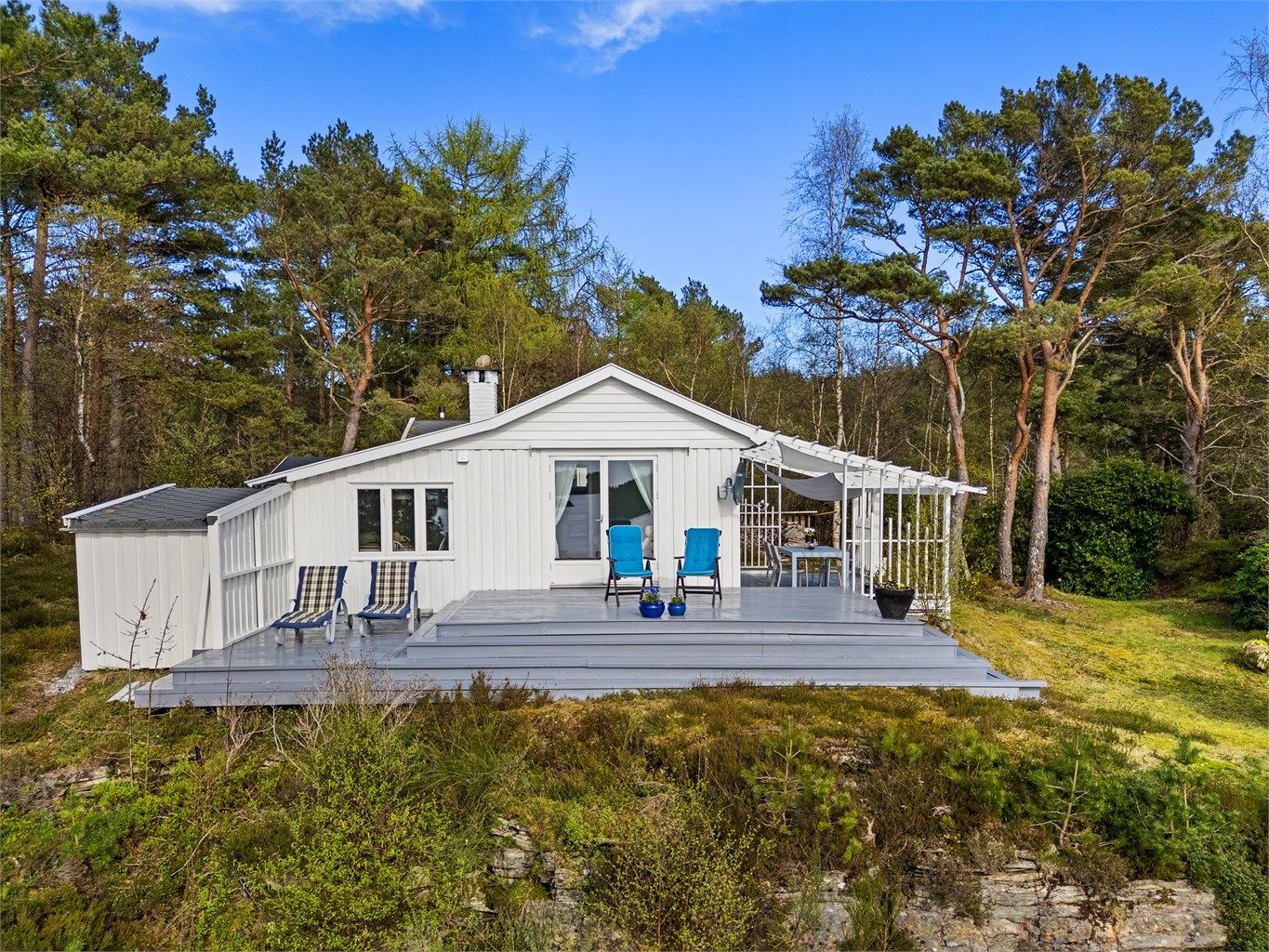 Utvendig stor og flott terrasse, hytten er omkranset med skog og natur og fremstår velholdt