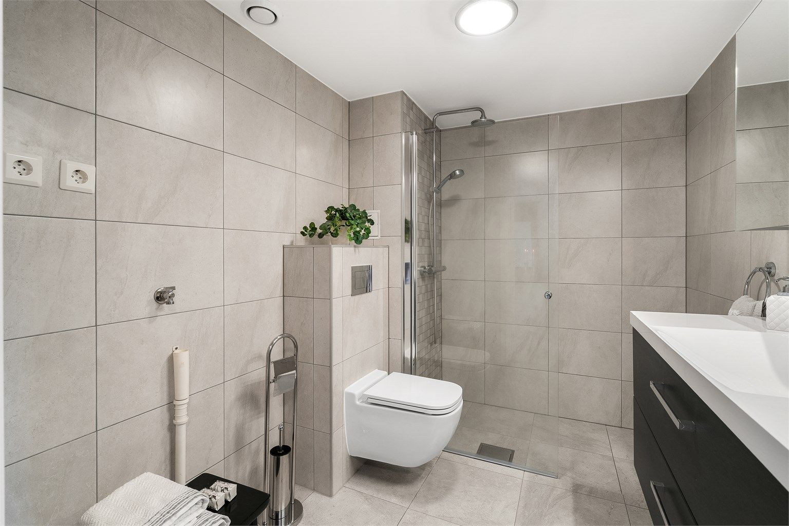 Pent og stilrent bad oppgradert i 2019. Nedsenket dusjsone med glassdør og regnfallsdusj. Opplegg for vaskemaskin og tørketrommel