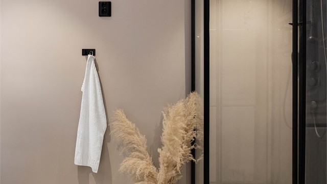 Badet har flislagt gulv med varme og vegger i malte flater, nedsenket himling med downlights.