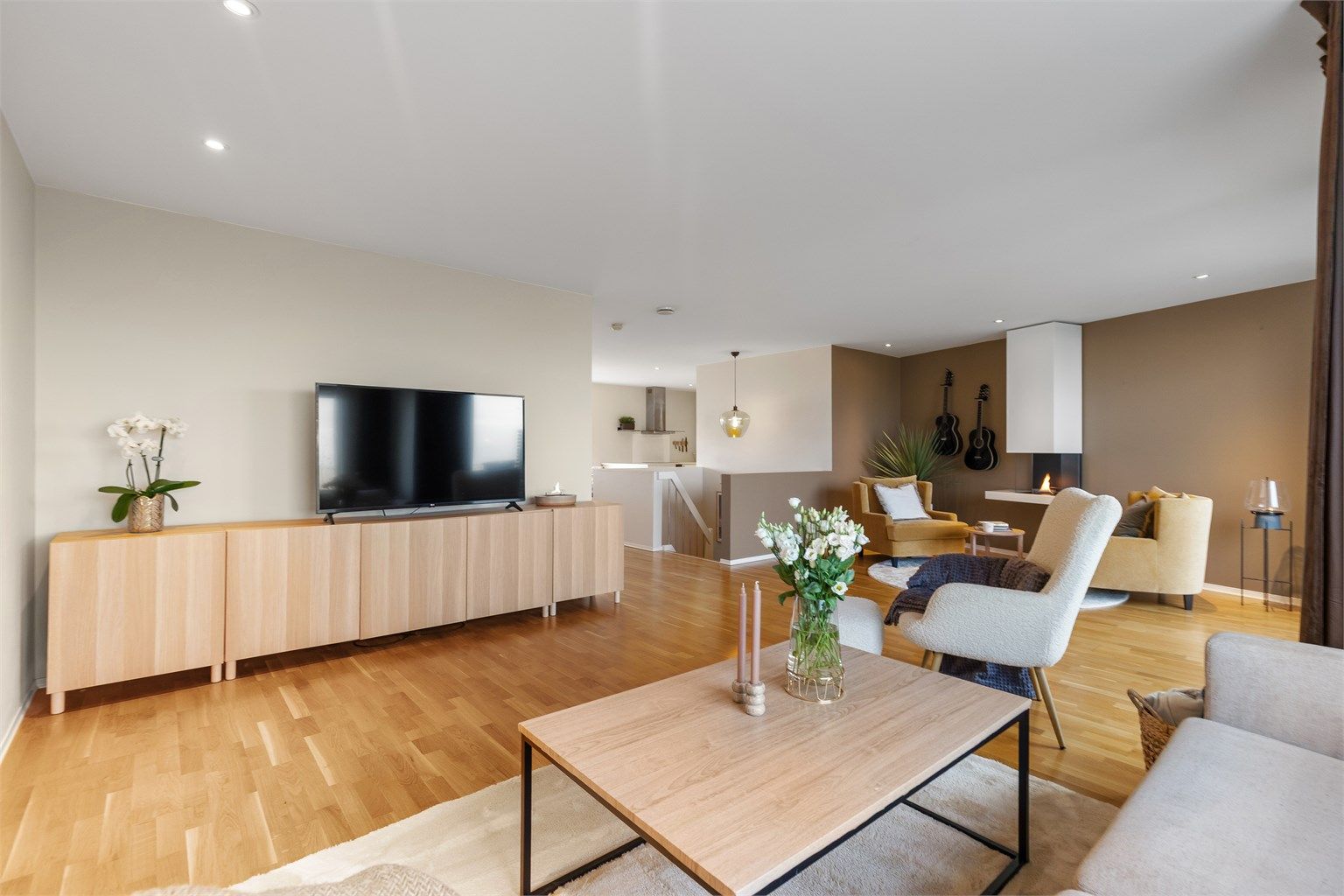 Delvis åpen stue- og kjøkkenløsning med romslige oppholdsarealer og naturlige soneinndelinger som gir en luftig og funksjonell planløsning.