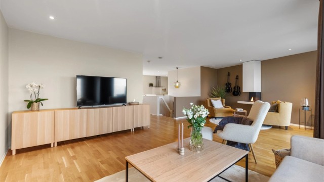 Delvis åpen stue- og kjøkkenløsning med romslige oppholdsarealer og naturlige soneinndelinger som gir en luftig og funksjonell planløsning.