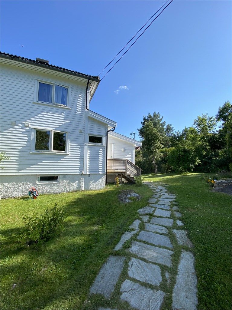 Eiendommen er et hageparadis på sommeren som både er praktisk og idyllisk, og du finner en skiferbelagt adkomst til huset. (privat foto)