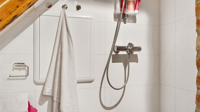 Videre er badet utstyrt med servant, toalett og dusjhjørne.