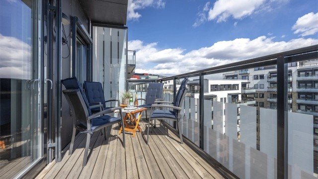God plass til blant annet utemøbler og grill. Her kan man samle gjester på besøk. Rekkverk av metall og glass. Gulvoverflater er belagt med terrassebord. Balkongen har utebelysning og utvendig stikkontakt