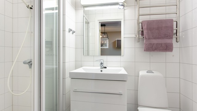 Flislagt bad med dusjnisje, servantinnredning og wc. Elektrisk håndkletørker