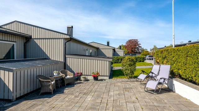 Inngangspartiet har en nyere støpt betongtrapp med varmekabel og rekkverk i glass og stål.