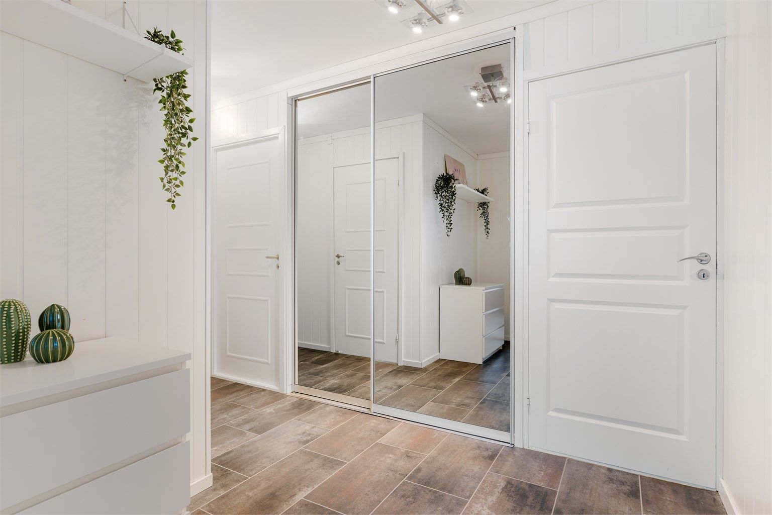 Speilskyvedørsgarderobe gir en ryddig og praktisk løsning med ytterligere oppbevaringsmuligheter. 