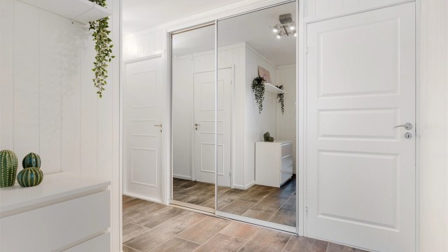 Speilskyvedørsgarderobe gir en ryddig og praktisk løsning med ytterligere oppbevaringsmuligheter.