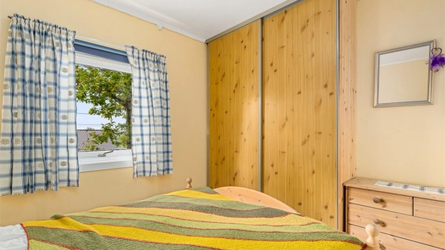Hovedhytta har to soverom. Dette rommet har god plass og en praktisk skyvedørsgarderobe.
