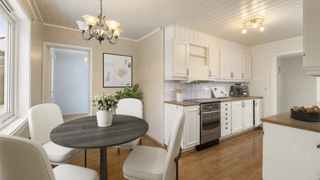 Kjøkkenet ligger i eget rom og har god plass til spisebord samt egen kjøkkeninngang. Selve kjøkkeninnredningen er fra ukjent årstall, med profilerte fronter og benkeplater av laminat. Digitalt stylet.