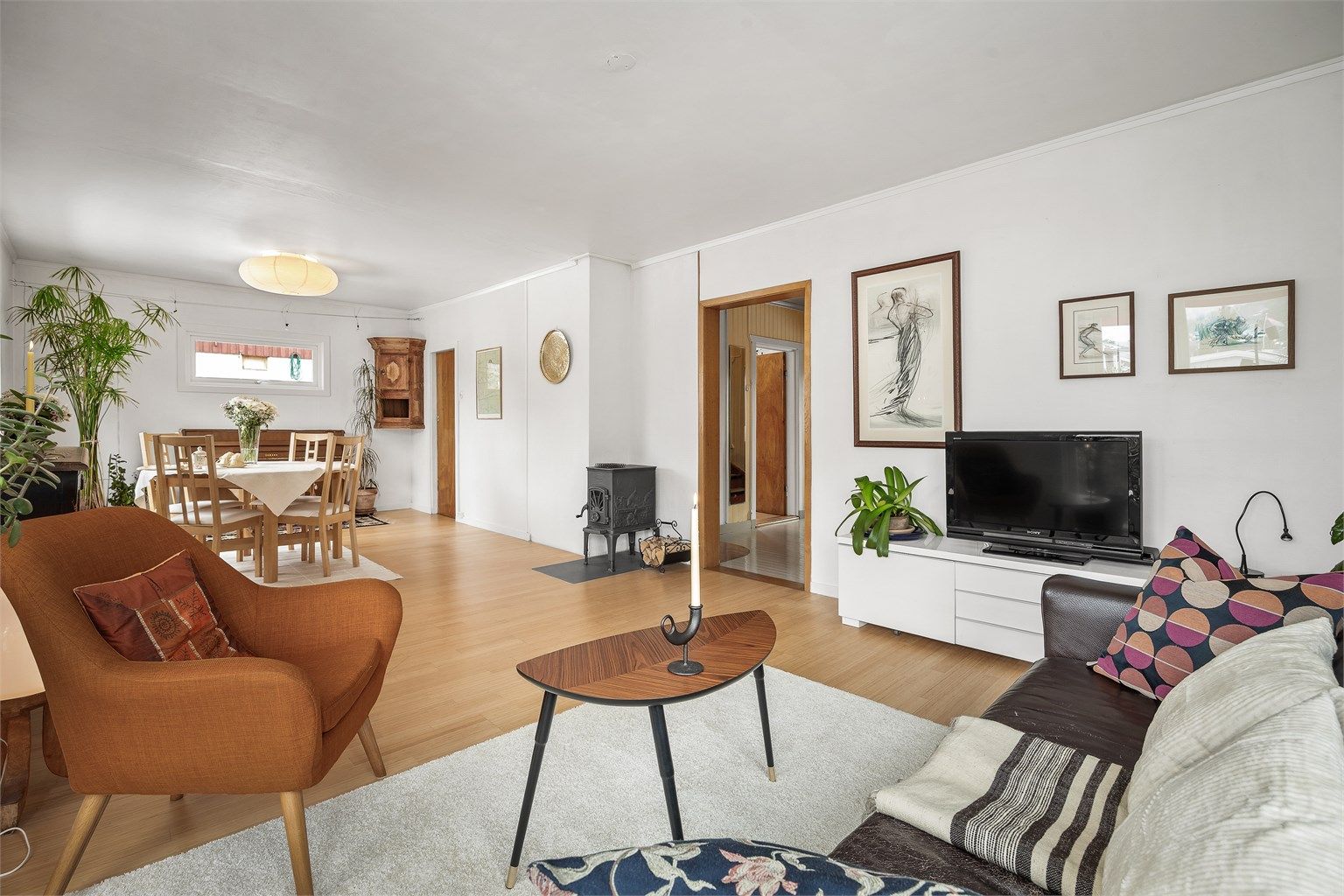 Frittstående rentbrennende Dovre vedovn fra 2018 med plate på gulv, pent plassert i midten av rommet