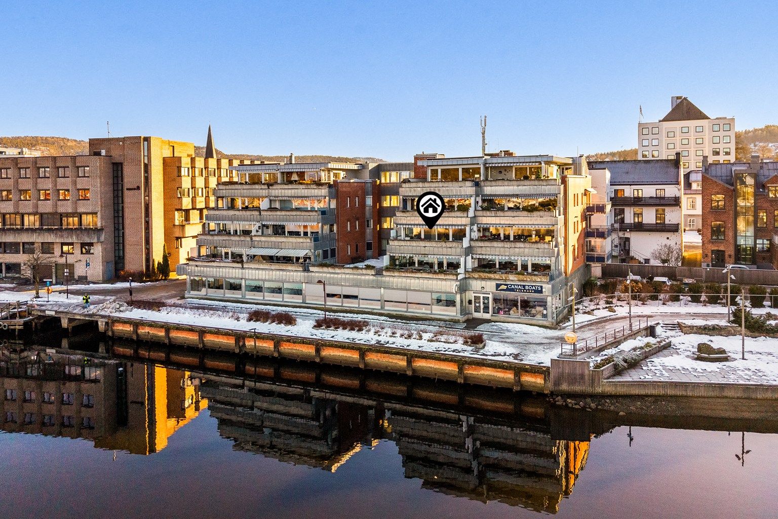 Leiligheten ligger sentralt i Porsgrunn sentrum på strandpromenaden i byggets 3. etasje. Det er næringslokaler i 1. etasje og boliger i de øvrige etasjene.