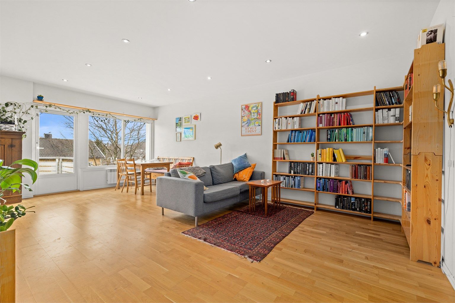 Stuen har parkett på gulv og god plass til både sofagruppe og spisebord.