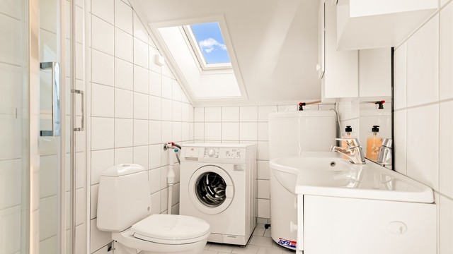 Badet har gulvstående toalett og dusjkabinett (2025).